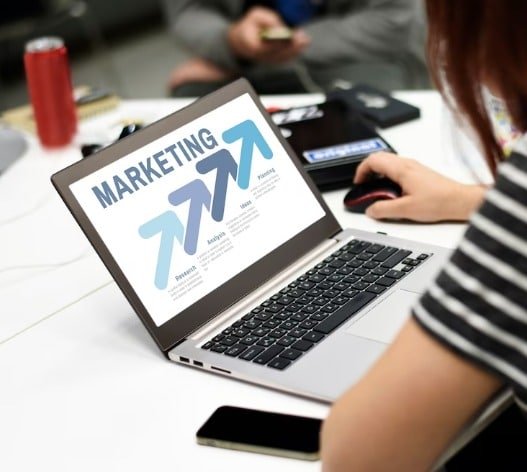 Mujer en una laptop leyendo unas diapositivas sobre marketing